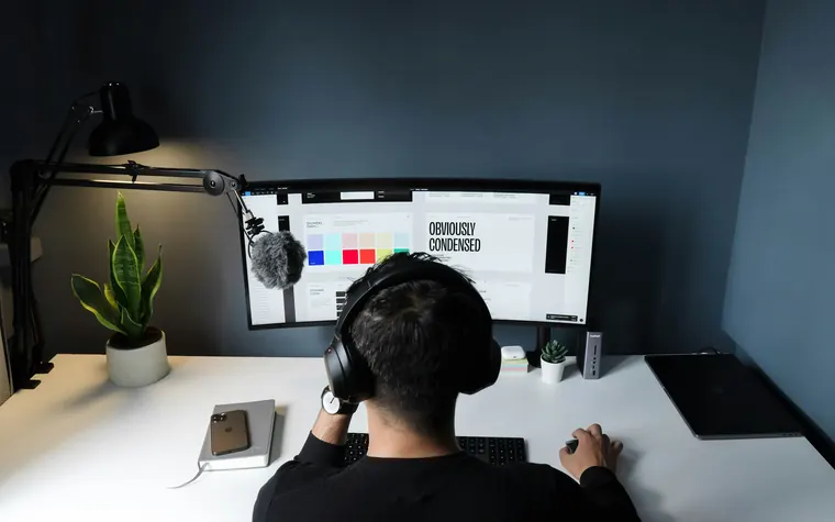 Puesto de trabajo con monitor ultrapanorámico y audífonos